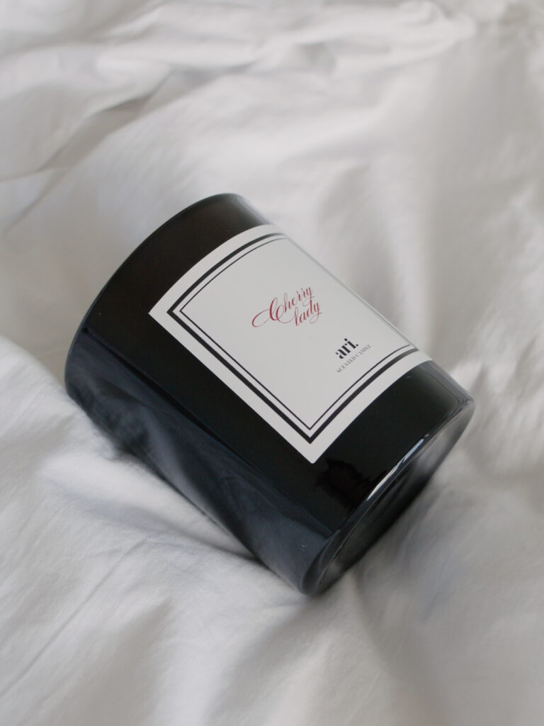 Vela perfumada artesanal ARI HOME com pavio de madeira em copo preto e etiqueta de luxo